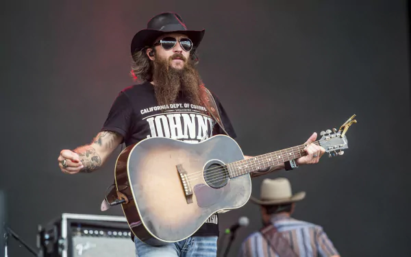 Cody Jinks performing with a guitar, in HD desktop wallpaper and background.