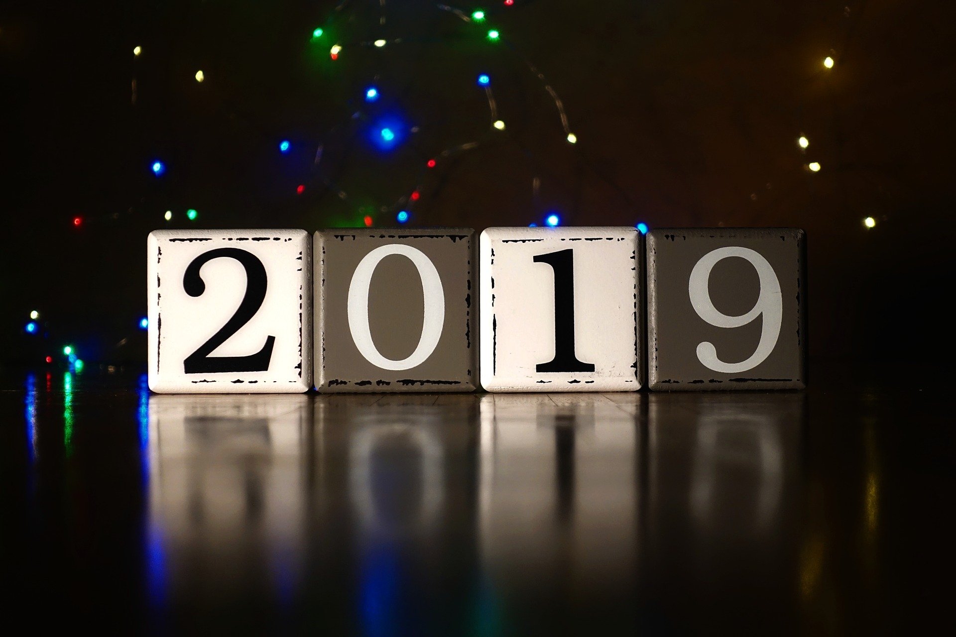 HD PC desktop wallpaper featuring illuminated blocks displaying 2019 with colorful holiday lights in the background, celebrating the New Year holiday.