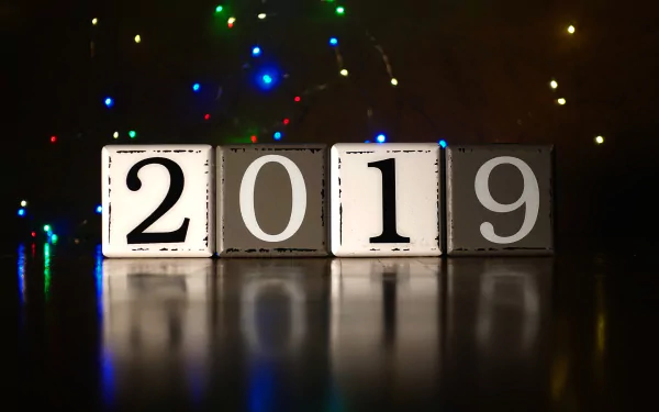 HD PC desktop wallpaper featuring illuminated blocks displaying 2019 with colorful holiday lights in the background, celebrating the New Year holiday.