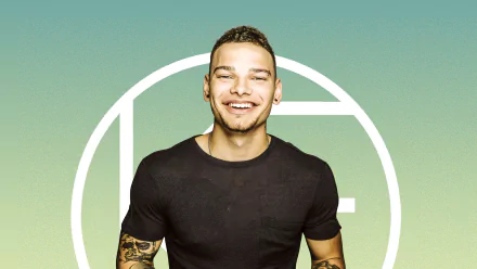 HD desktop wallpaper featuring a smiling man with tattoos, set against a teal background with a white circular design.
