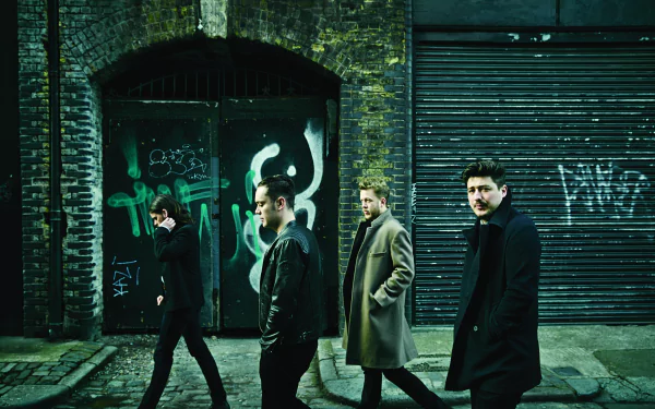 A striking HD wallpaper featuring Mumford & Sons walking together in an urban setting, with graffiti-covered walls adding to the dynamic music-inspired atmosphere.