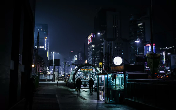 Nighttime street scene in Seoul featuring illuminated buildings and a bus stop, captured in 4K Ultra HD for a crisp, detailed man-made urban atmosphere.