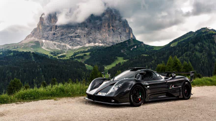 A sleek black Pagani Zonda supercar parked on a mountain road, set against a dramatic cloudy sky and lush green hills in this 4K Ultra HD desktop wallpaper.
