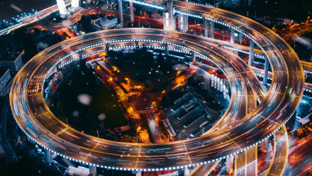Nanpu Bridge, Shanghai, China — night aerial of spiral man-made highway with time-lapse light trails; 2K Quad HD PC desktop wallpaper/background.