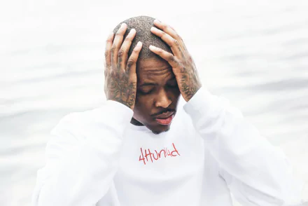HD desktop wallpaper featuring a person with hands on head, wearing a shirt with the text 4Hunnid, on a blurred background.