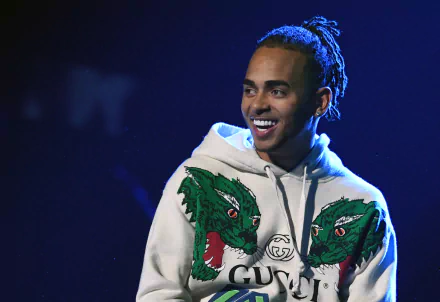 HD wallpaper of a smiling man in a hoodie with a dragon design, tagged as Ozuna, suitable as a desktop background.
