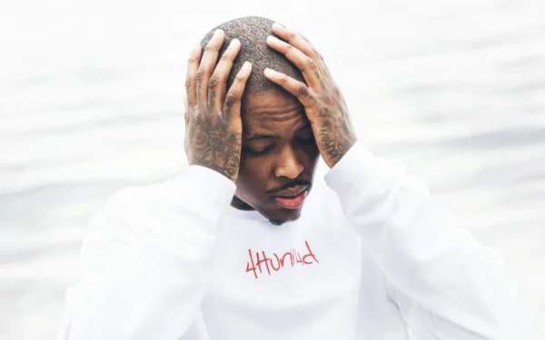 HD desktop wallpaper featuring a person with hands on head, wearing a shirt with the text 4Hunnid, on a blurred background.