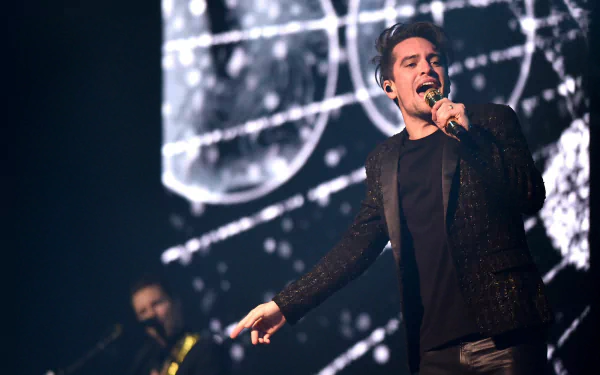 HD desktop wallpaper of a Panic! at the Disco concert with the lead singer performing onstage.