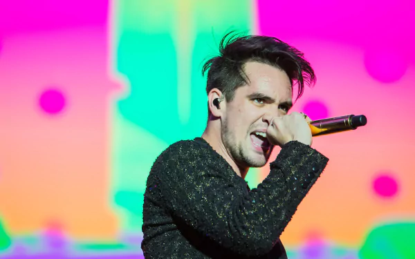 HD desktop wallpaper of a Panic! at the Disco performance with vibrant background colors and a focused singer onstage.