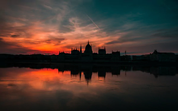Sunset over the Hungarian Parliament Building along the Danube River, with vibrant evening colors reflecting on the water in a 4K Ultra HD scene.
